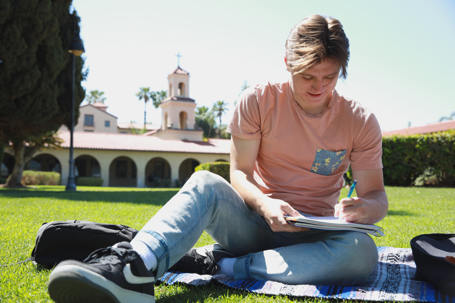 Student sitting on campus lawn