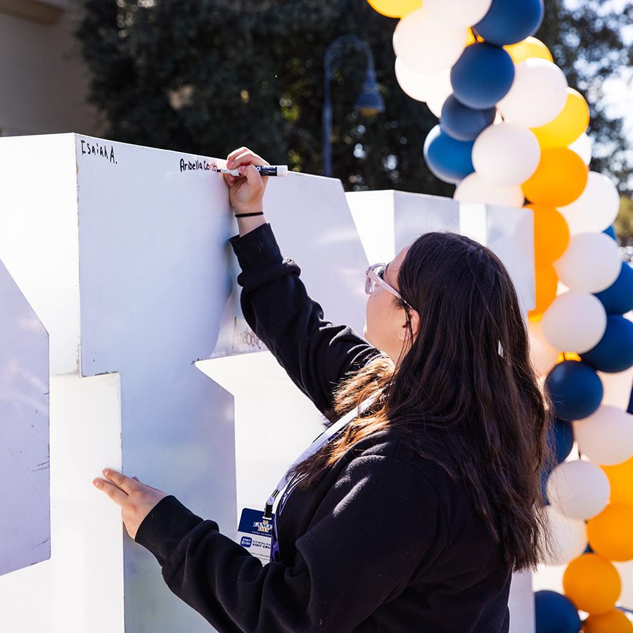 Prospective student writing name on CBU Logo