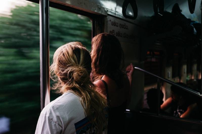 Two women looking out the window of a moving train