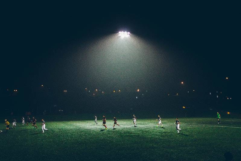 Soccer players on a field at night under the lights