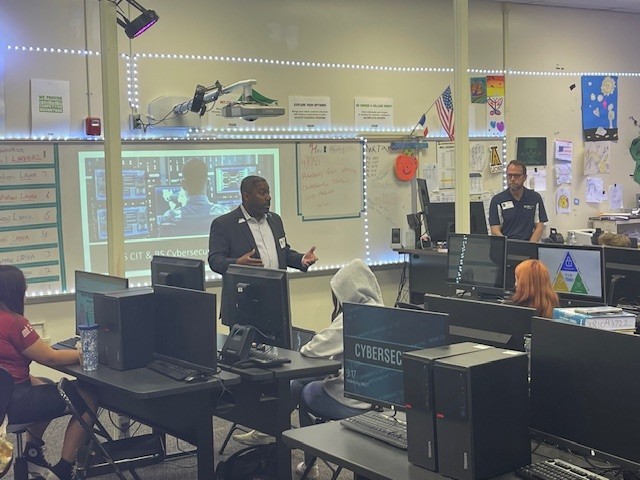 Professors talking with students in a classroom at Arlington High School