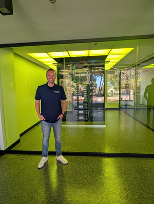 Professor standing next to new supercomputer