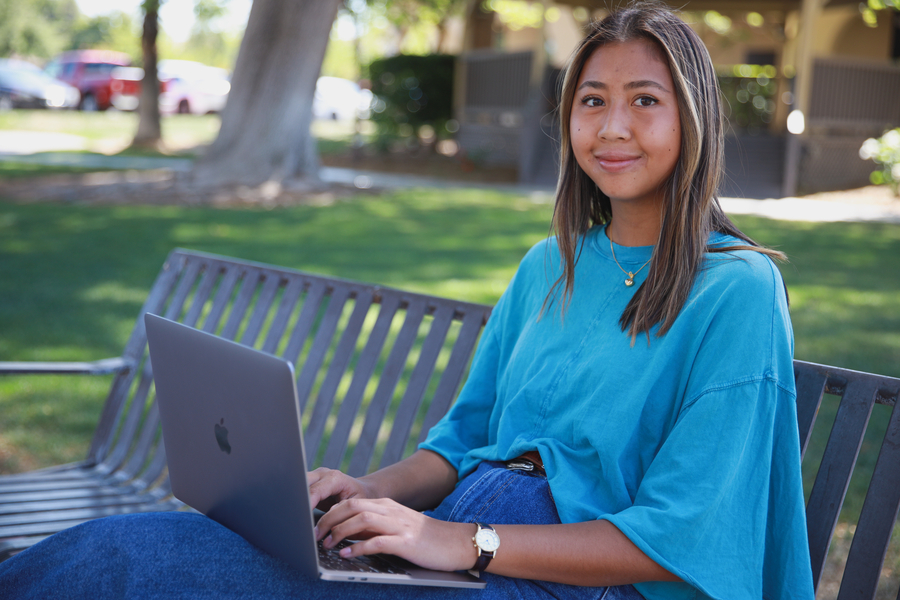 A CBU graduate student working on a laptop computer