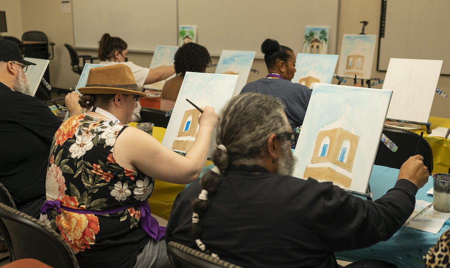 people painting on canvases