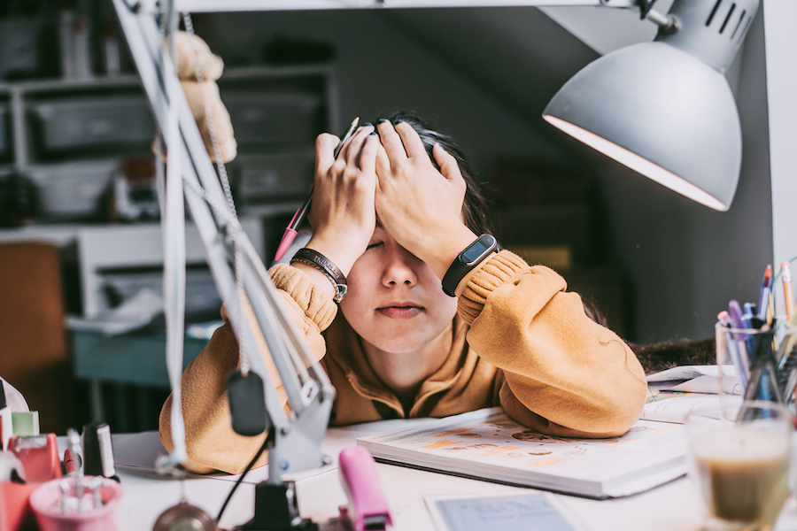 girl with hands on her face at desk