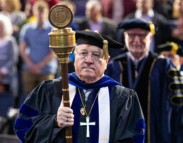 man hold mace at commencment