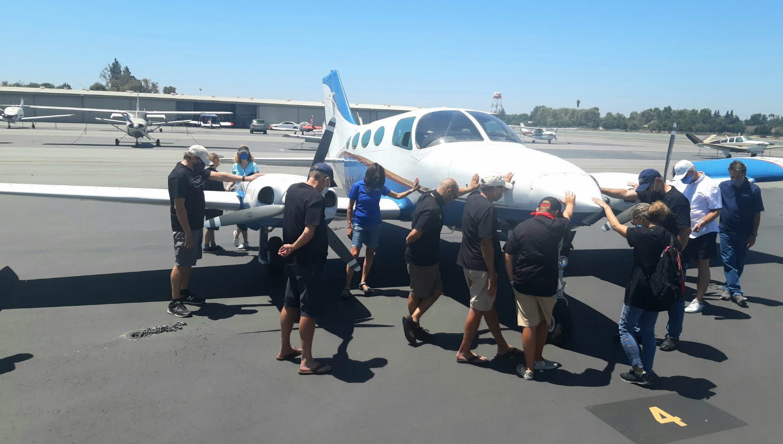 CBU Faculty and students praying over an aircraft