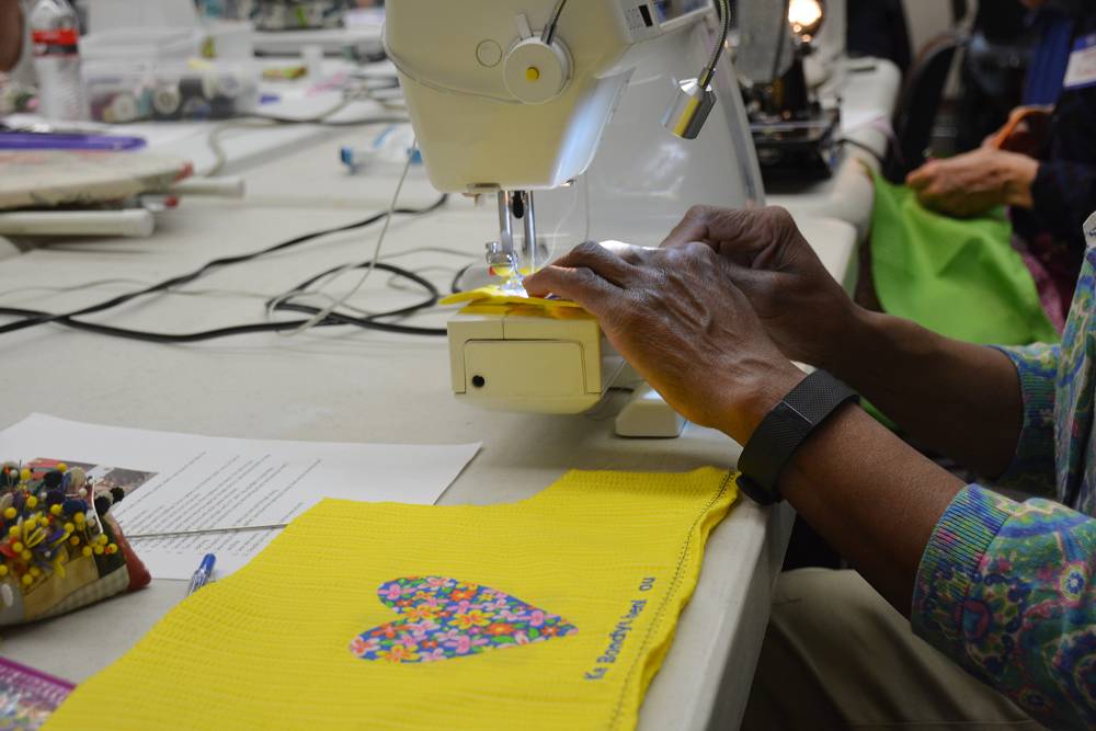 More than 25 sewing machines whirred and hummed as women stitched                       fabric, sequins, buttons and thread into unique patterns to create dresses for                       young girls in Haiti. 