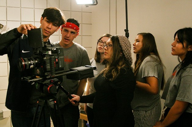 Several high school students around a video camera