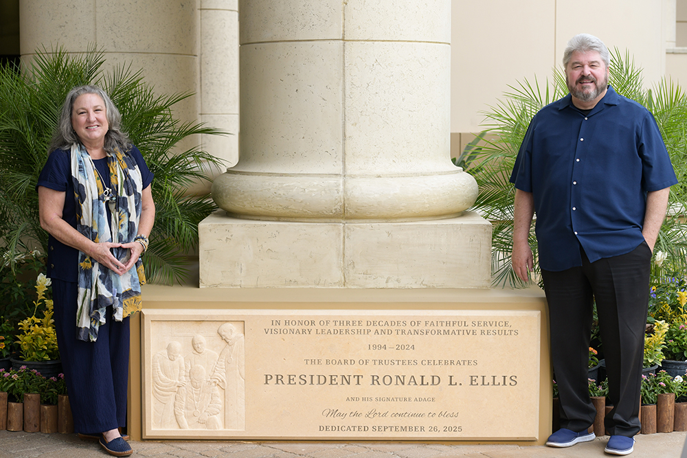couple standing by stone sign