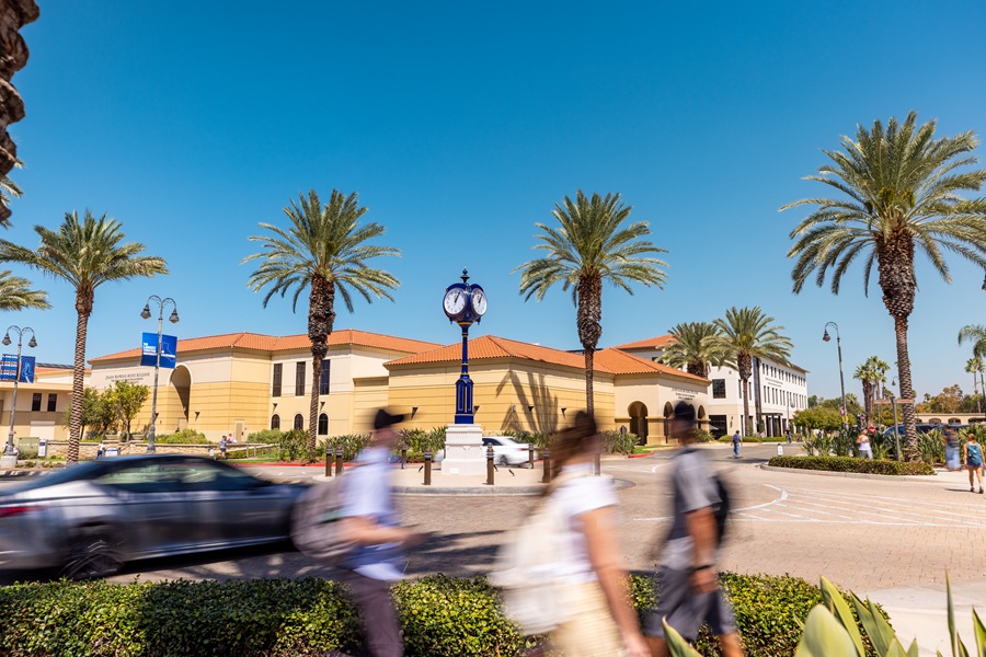 Students walking by with the School of Performing Arts in the background