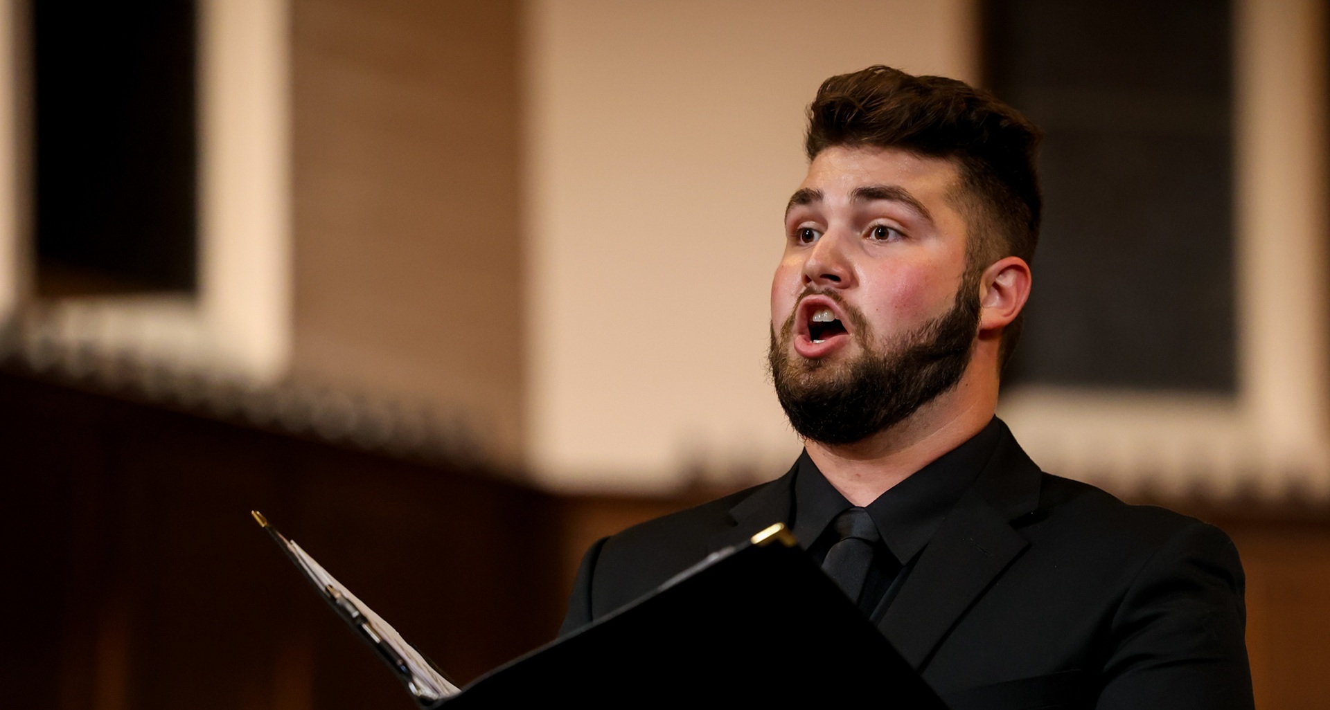 Man singing with a book in his hands