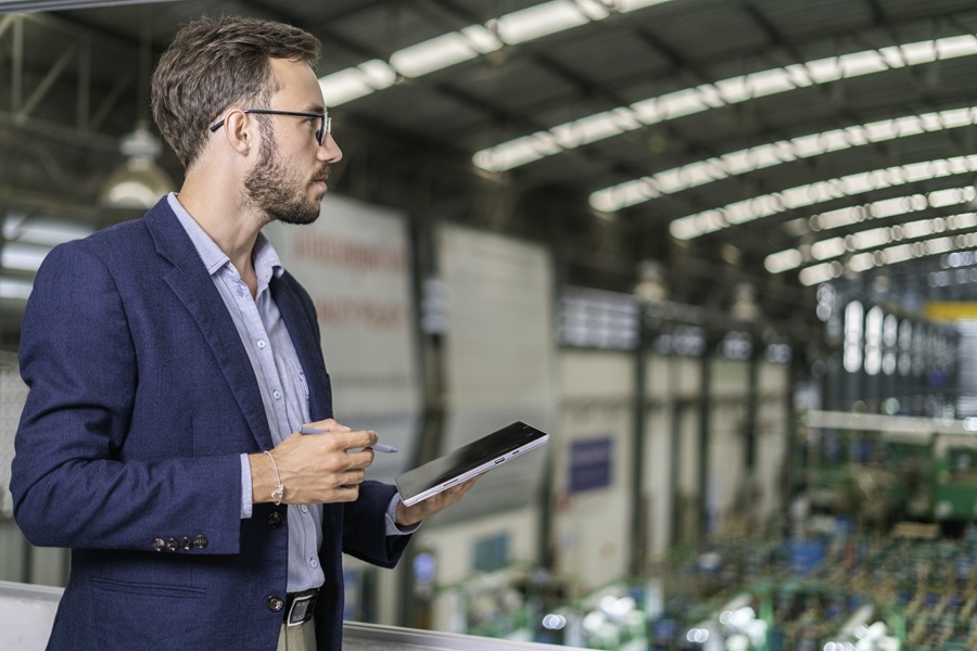 Man analyzing a warehouse and inputting data into a tablet