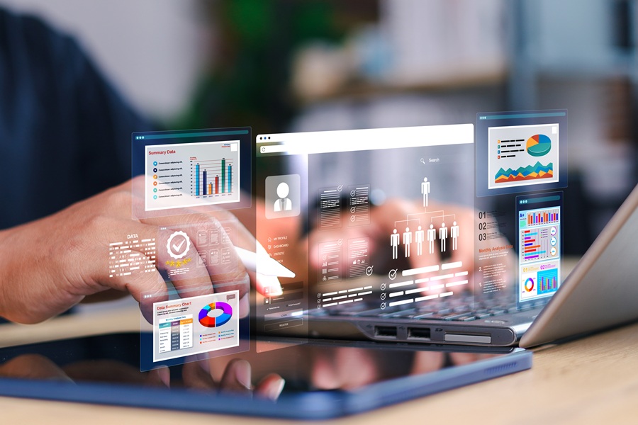 A person's hands working on a laptop and tablet with a data overlay on top of the picture
