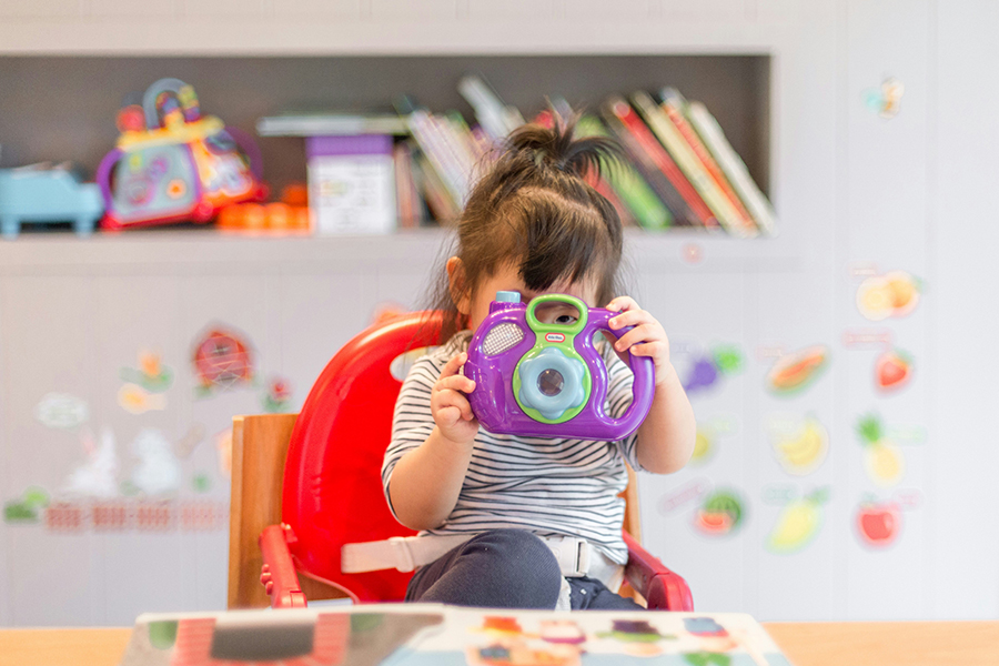 child holding camera