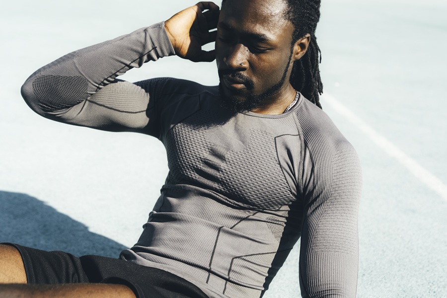 Man in athletic wear doing sit-ups on a court
