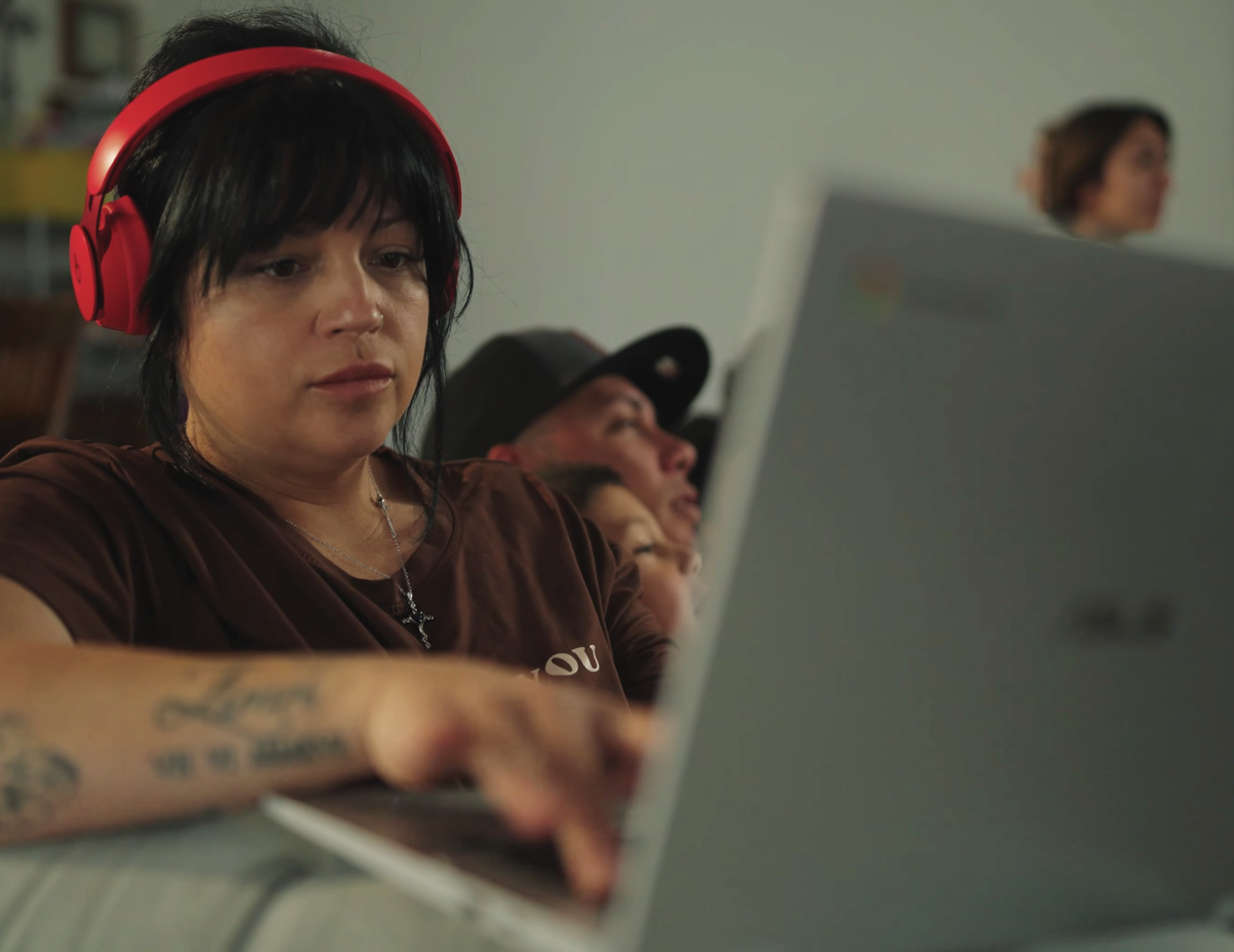 Student using laptop with red headphones on