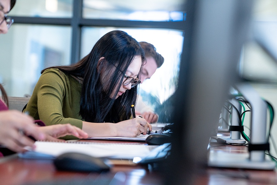Business student writing down notes
