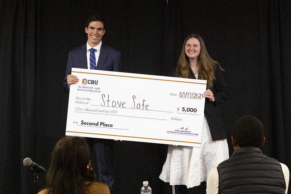 2 people holding large check