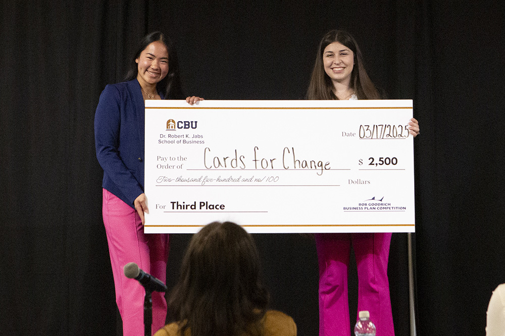 2 people holding large check