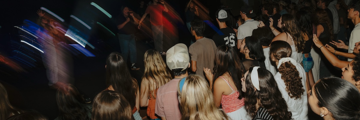 students worshiping near stage of musicians